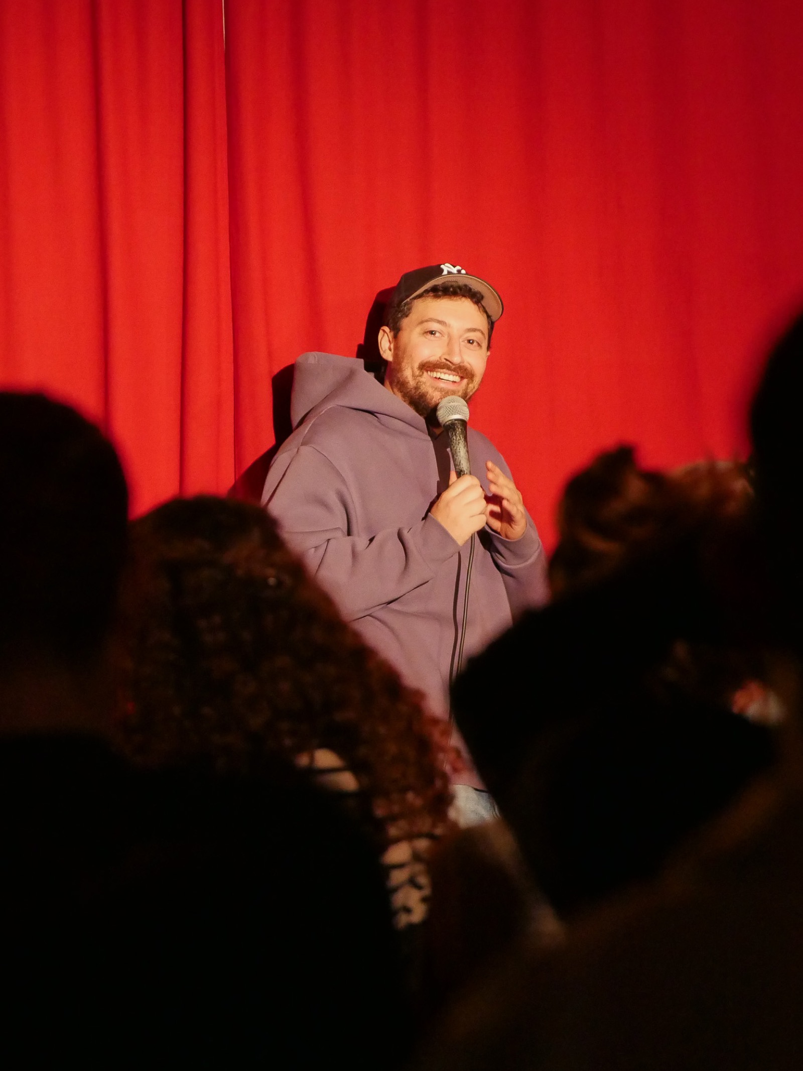 Comedian vor rotem Vorhang bei WIR ARBEITEN DRAN